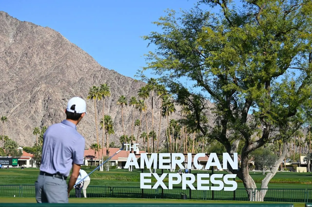 Cameron Rajput walking the fairway past The American Express sign